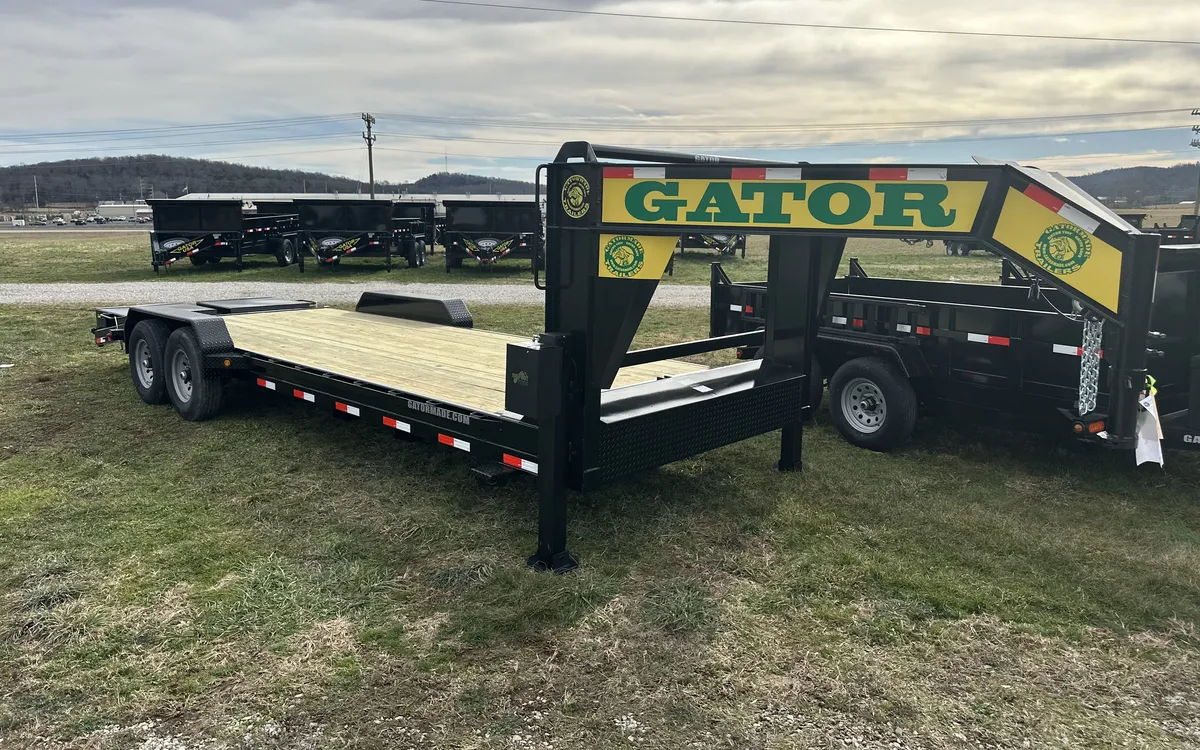 Gatormade gooseneck trailer parked on the factory lot with rows of dump trailers behind it